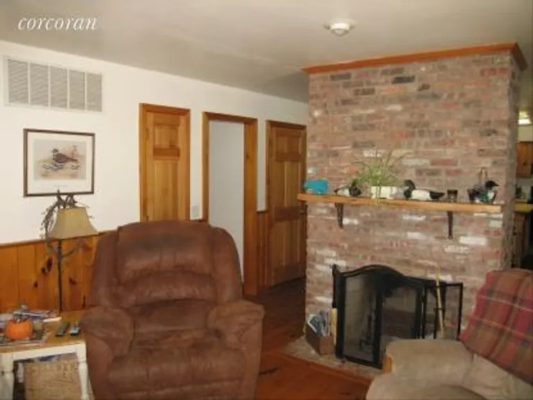 New York City Real Estate | View 7 Quail Run | Living Room with Brick Fireplace | View 6
