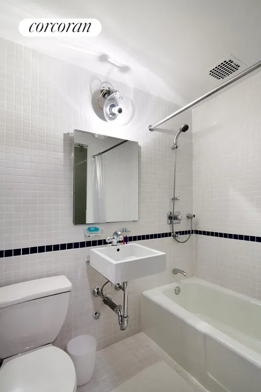 New York City Real Estate | View 9 Barrow Street, 3H | Sparkling white tiles w/ storage behind mirror | View 4