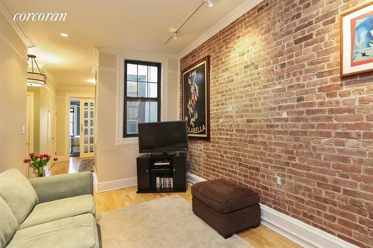 New York City Real Estate | View 434 West 47th Street, 4E | Living room features exposed brick and two windows | View 3