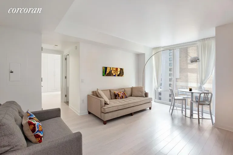 New York City Real Estate | View 247 West 46th Street, 1505 | Living room with floor-to-ceiling window | View 2