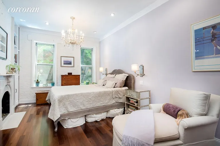 New York City Real Estate | View 92 Horatio Street, 1L | Bedroom with gas fireplace overlooking garden | View 4