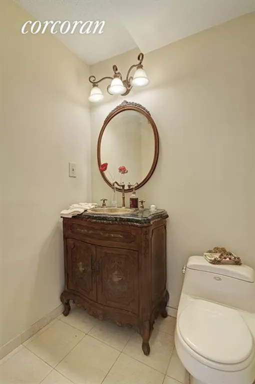 New York City Real Estate | View 115 East 87th Street, 39E | Powder Room w/bronze sink and wood vanity. | View 9
