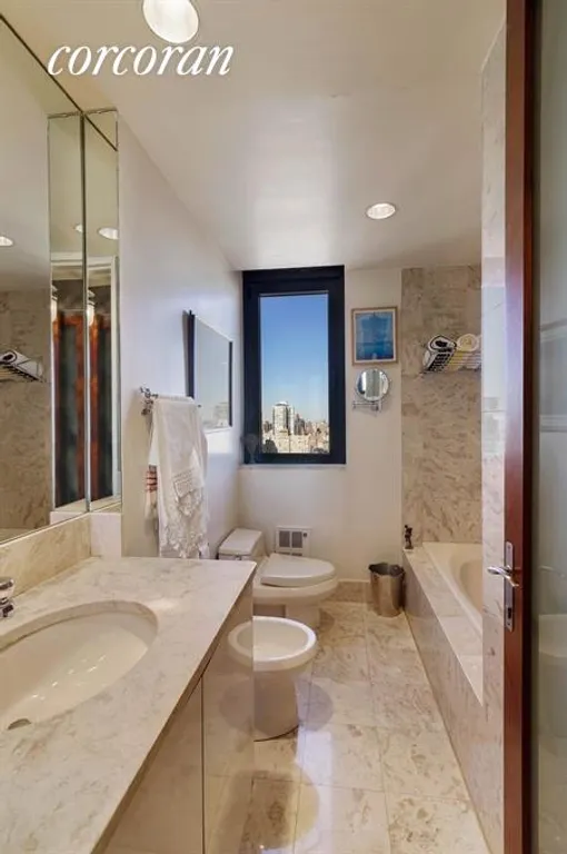 New York City Real Estate | View 100 United Nations Plaza, 42E | Windowed Marble Bathroom with Stall Shower & Tub | View 5