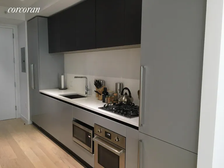 New York City Real Estate | View 540 West 49th Street, 402S | Fridge & Dishwasher built in to cabinetry  | View 4