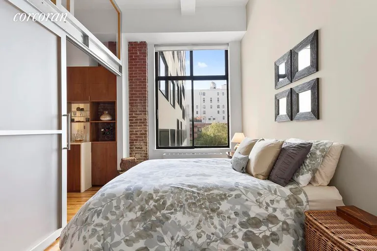 New York City Real Estate | View 77 Bleecker Street, 620 | Huge South-facing window & industrial door in BR | View 4