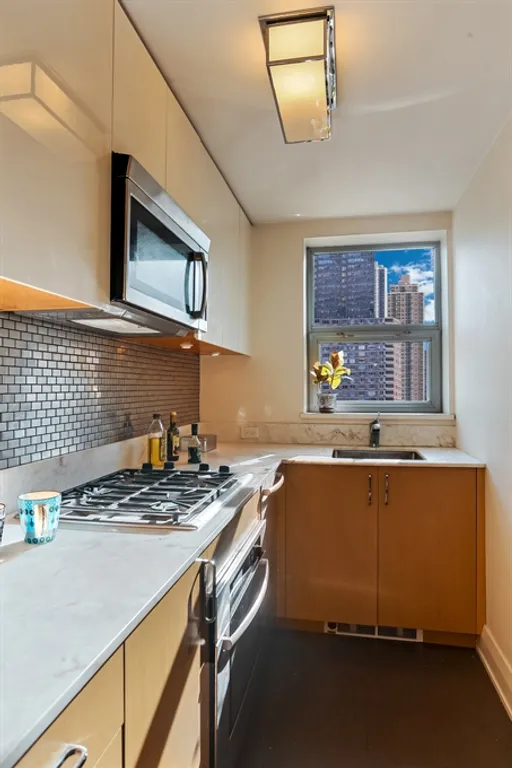 New York City Real Estate | View 211 East 51st Street, 10G | Windowed chef's kitchen with stainless appliances | View 5