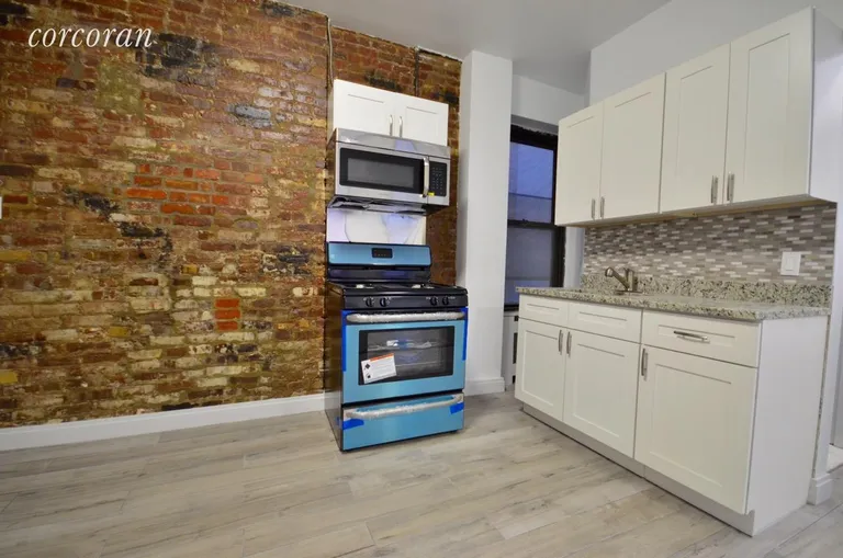 New York City Real Estate | View 202 Thompson Street, 14 | Exposed brick and stainless steel appliances | View 2