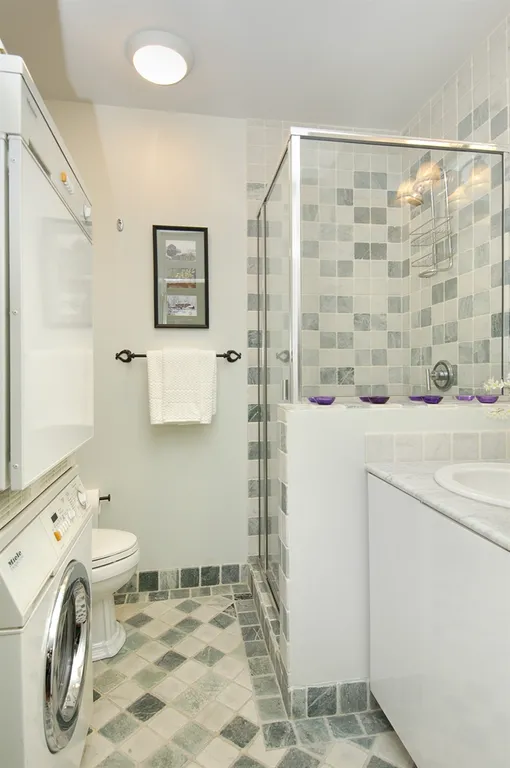 New York City Real Estate | View 22 West 66th Street, 2A | Large guest bath with glass shower & washer/dryer | View 8