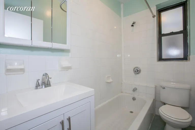 New York City Real Estate | View 489 Montgomery Street, 1-R | with new vanity and nice sized tub + window. | View 8