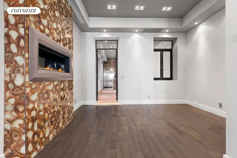 New York City Real Estate | View 310 East 69th Street | Main living room with glass fireplace. | View 3