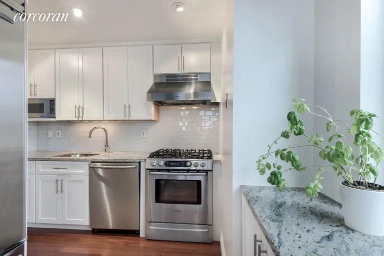 New York City Real Estate | View 404 East 76th Street, 20A | Renovated, windowed kitchen with eating counter | View 3
