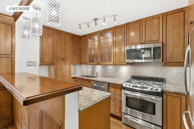 New York City Real Estate | View 225 East 57th Street, 8F | Kitchen w/ Breakfast Bar and Custom Cabinetry | View 2
