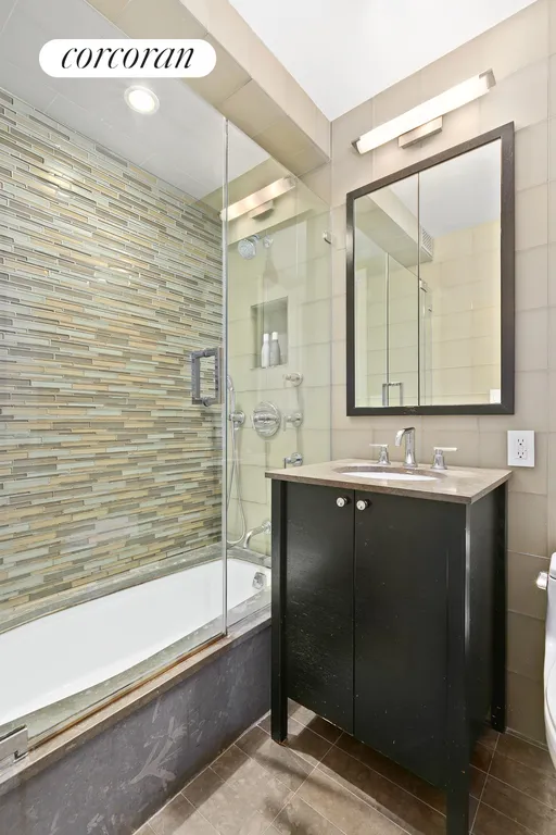 New York City Real Estate | View 203 East 72nd Street, 5B | Guest Full Bath with glass tiles and stone floor | View 7