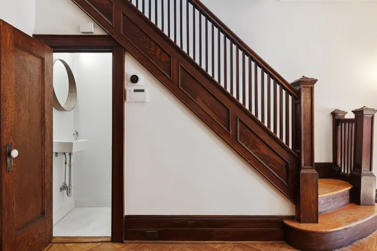 New York City Real Estate | View 30 Chester Court | Half bathroom under the elegant staircase | View 5