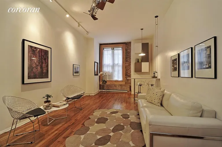 New York City Real Estate | View 23 Waverly Place, 4R | West-facing living/dining area with exposed brick | View 2