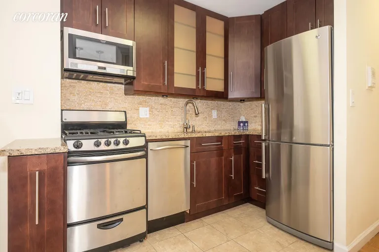 New York City Real Estate | View 353 East 72Nd Street, 24B | Stainless appliances and attractive dark wood | View 9