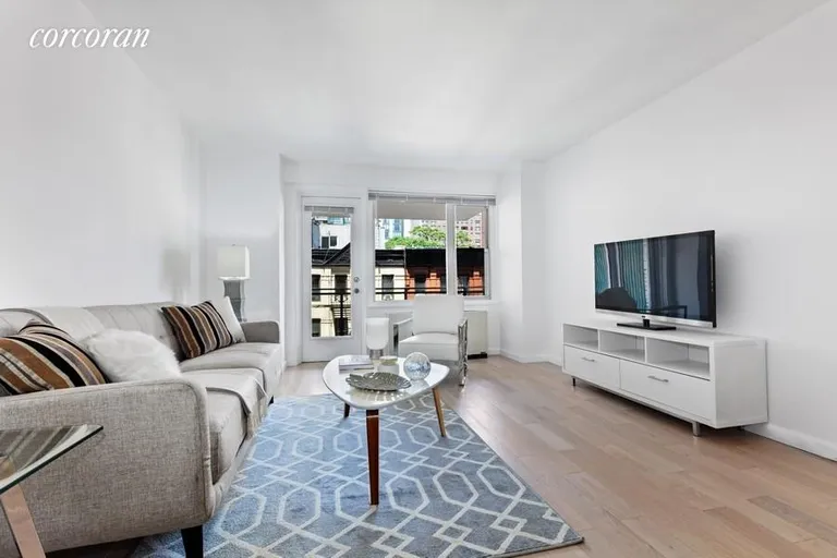 New York City Real Estate | View 400 East 77th Street, 6B | Living Room Leading To Balcony | View 2