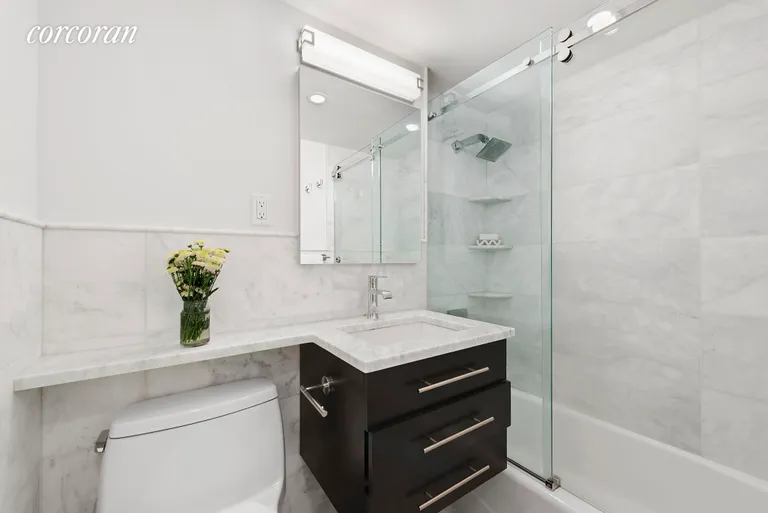 New York City Real Estate | View 220 East 57th Street, 10E | Marble Bath with glass shower doors | View 5